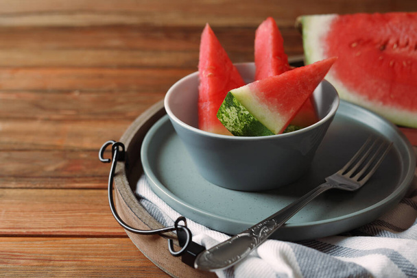Sliced fresh juicy watermelon and fork on wooden table, closeup. Space for text - Фото, зображення