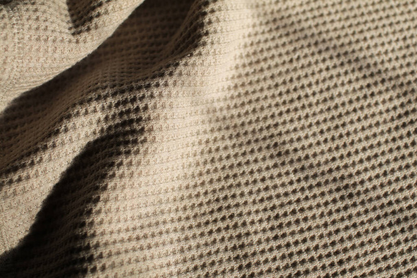 Beige waffle weave cotton fabric with light and shadow. Closeup of light natural cotton texture pattern for background. - Photo, Image
