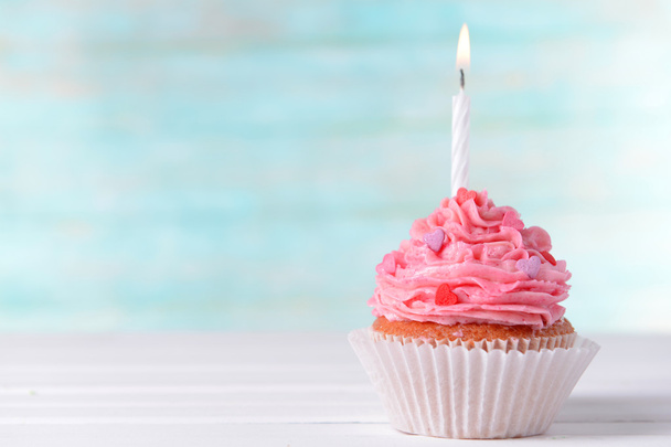Delicious birthday cupcake on table on light blue background - Фото, изображение