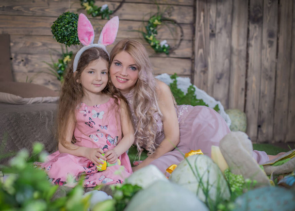 Маленька дівчинка у вухах кролика та її мати  - Фото, зображення
