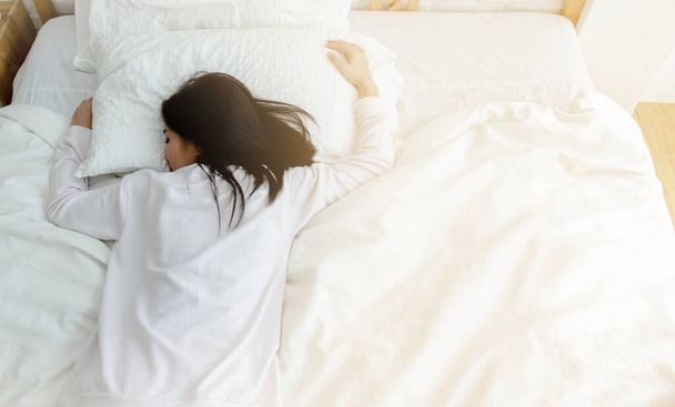 Mujer asiática joven en la cama. Concepto de salud en el sueño - Foto, imagen