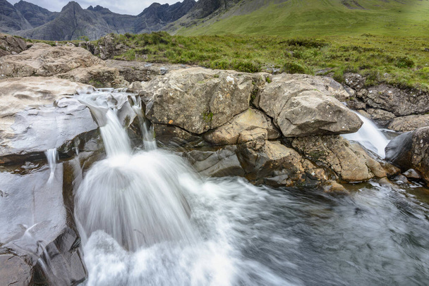 Long line of waterfalls and rocky mountain pools at the foot of the Black Cuillin Mountains,popular tourist site,spectacular Skye scenery,a steep path with boulders and swimming areas. - Zdjęcie, obraz