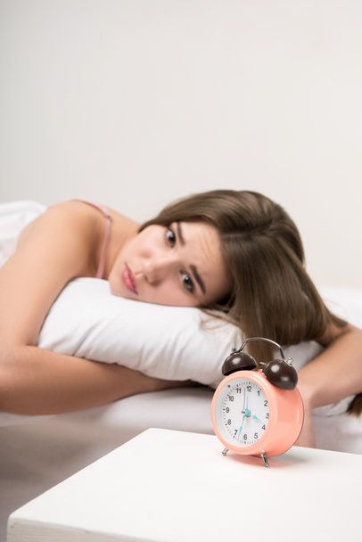 beauty lying on the bed with a clock - Foto, imagen
