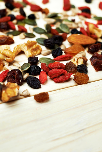 Meng noten zaden en droge vruchten, op een houten tafel - Foto, afbeelding