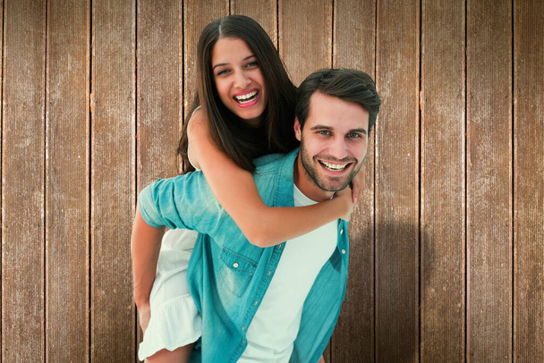 "Composite image of happy hipster giving his girlfriend a piggy back" - Photo, Image