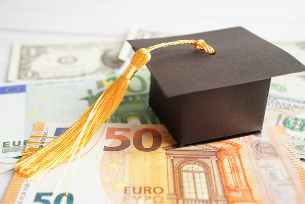Graduation gap hat on Euro and US dollar banknotes money, Education study fee learning teach concept. - Photo, Image