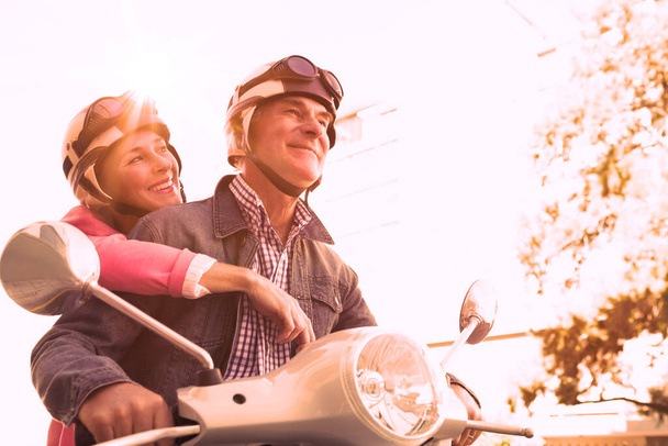"feliz casal sênior montando um ciclomotor
 " - Foto, Imagem