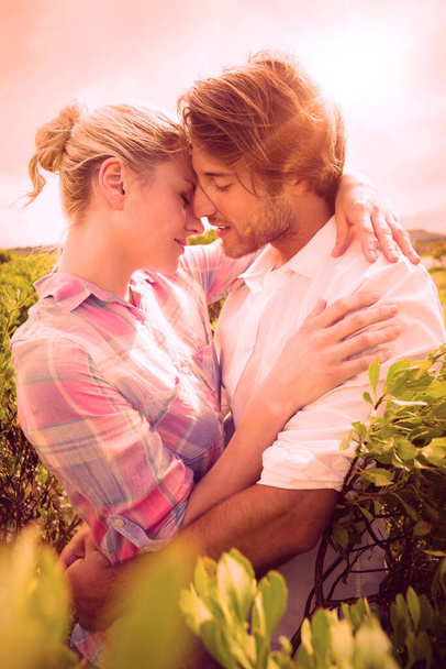 "Smiling couple embracing outside among the bushes" - Foto, Bild