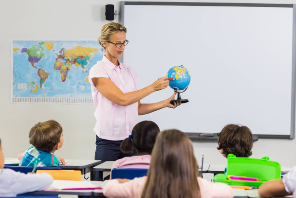 Teacher having lesson with a globe - Photo, Image