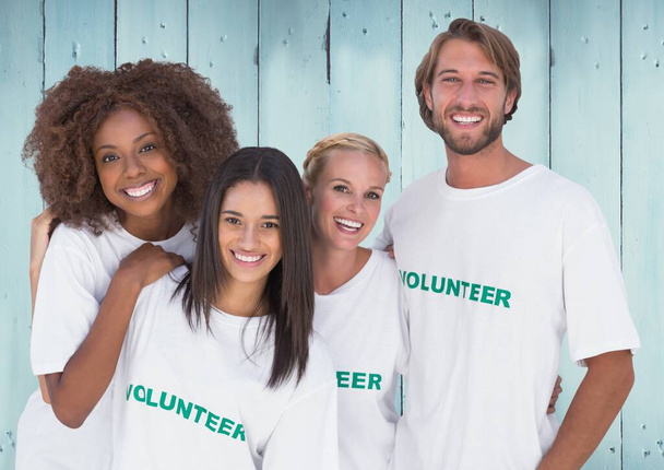Ομάδα χαρούμενα εθελοντής κατά μπλε ξύλινο φόντο - Φωτογραφία, εικόνα
