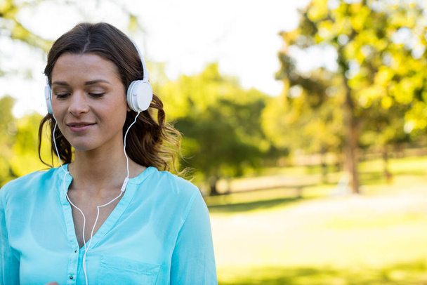 Nainen kuuntelee musiikkia kuulokkeissa - Valokuva, kuva