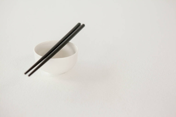 Пара палочек для еды из Азии на белом столе - Фото, изображение