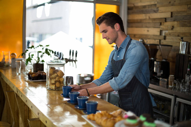 Waiter preparing cup of coffee at counter - Photo, Image