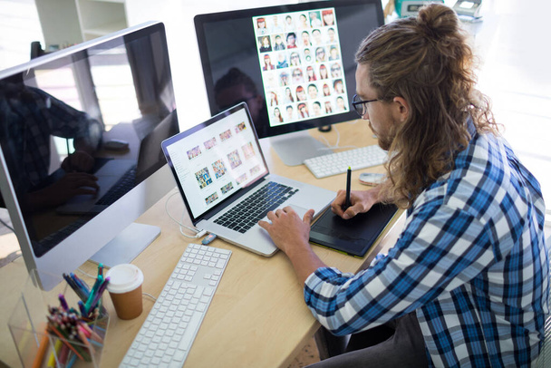 Männliche Führungskräfte arbeiten am Schreibtisch über Laptop und Grafik-Tablet - Foto, Bild