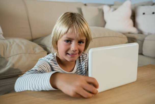 Хлопчик використовує цифровий планшет у вітальні вдома
 - Фото, зображення