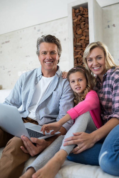 Happy rodina pomocí notebooku společně v obývacím pokoji - Fotografie, Obrázek