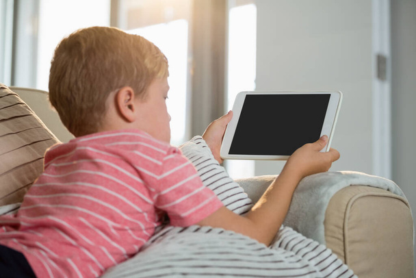 Menino usando tablet digital na sala de estar
 - Foto, Imagem