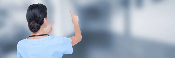 Doctor measuring with fingers against blue blurred hallway - Photo, Image