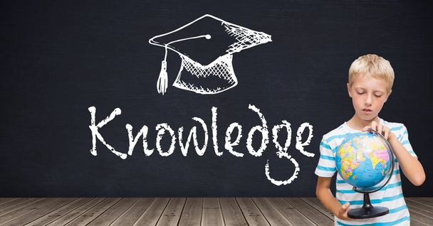 Boy holding world globe and Knowledge text and graduation education hat on blackboard - Photo, Image
