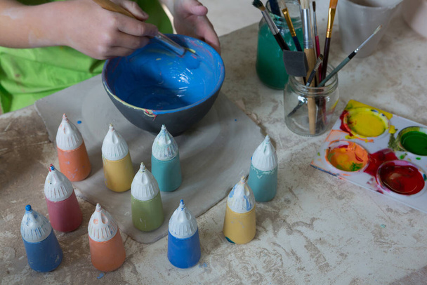 Хлопчик малює чашу в керамічному магазині
 - Фото, зображення