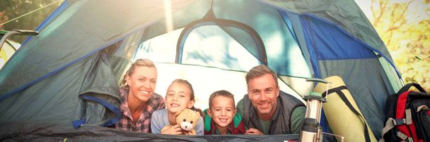 Lachende familie liggen in de tent - Foto, afbeelding