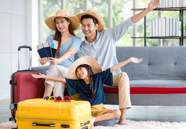 Millennial Asian happy family father and little girl daughter wearing casual summer travel outfit preparing packing stuff in trolley luggage ready to vacation holiday in living room at home. - Фото, изображение