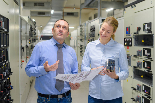 industrial professionals talking in a machine room - Фото, зображення
