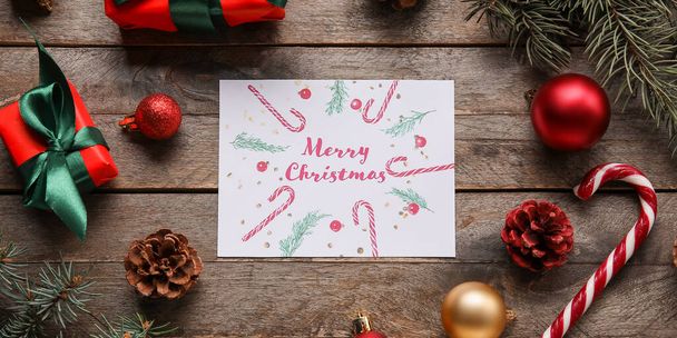 Ευχετήρια κάρτα για Καλά Χριστούγεννα, διακοσμήσεις και δώρα σε ξύλινο φόντο - Φωτογραφία, εικόνα