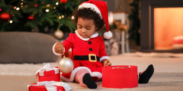 Aranyos afro-amerikai kislány ajándékokkal otthon karácsony este - Fotó, kép
