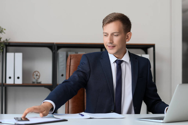 Young bank manager working at table in office - Photo, Image