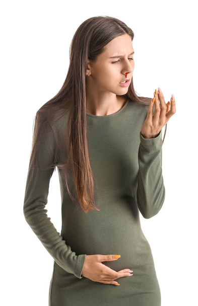 Young pregnant woman with nosebleed on white background - Φωτογραφία, εικόνα