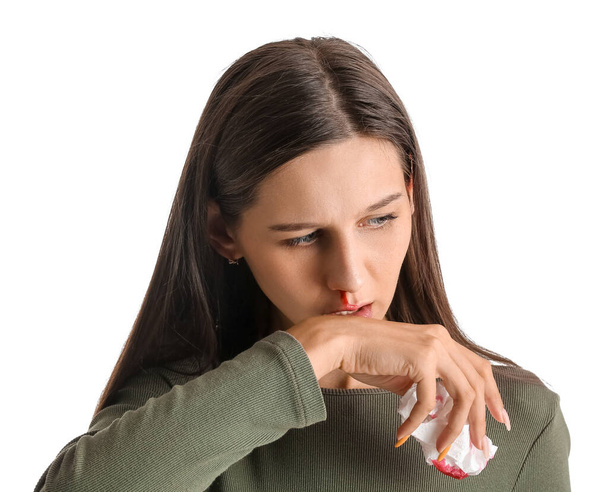 Young woman with nosebleed and tissue on white background, closeup - Photo, Image