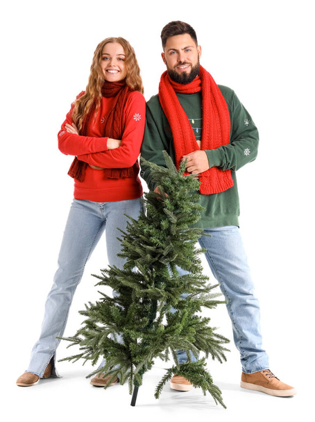 Happy young couple with Christmas tree on white background - Photo, Image