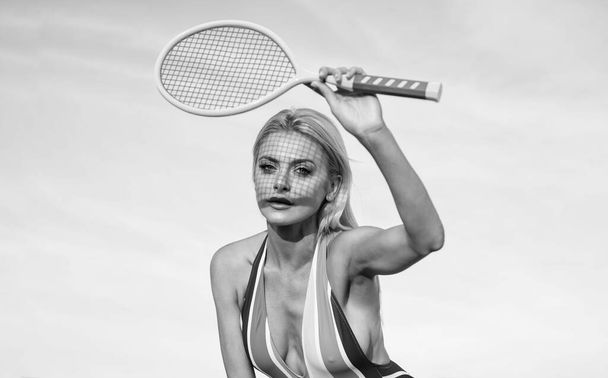 summer activity. active lifestyle. girl in bikini on beach with racket. sportswoman in beachwear. sexy woman in striped colorful swimsuit. female tennis player. badminton racquet. sport and hobby. - Valokuva, kuva