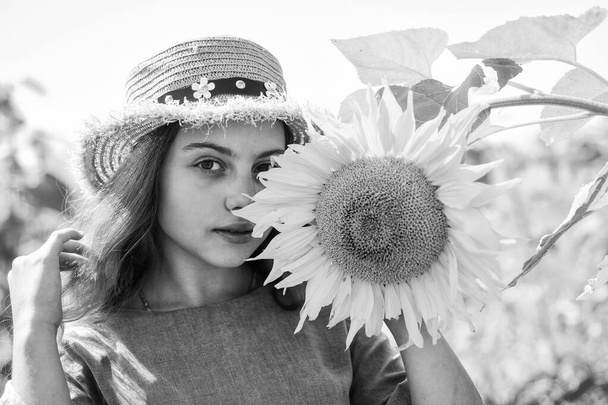 Beautiful face little girl playing sunflowers nature background, cosmetics concept. - Фото, изображение