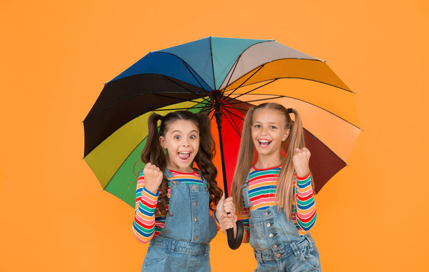 Safe place. Fashion accessory. Girls friends with umbrella. Rainy day. Happy childhood. School time. Rainbow umbrella. Colorful life. Schoolgirls happy umbrella. Fall weather forecast. Safety concept. - Fotoğraf, Görsel
