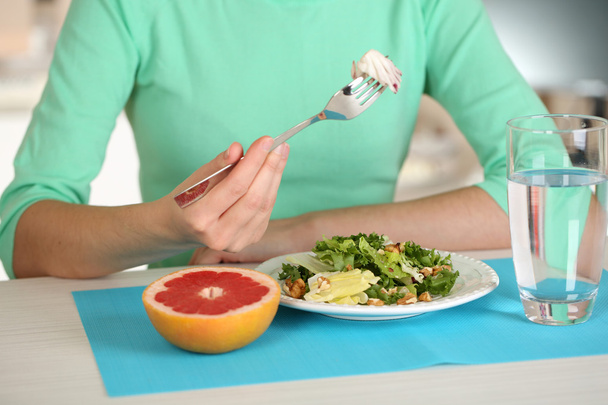 Chica y comida dietética en primer plano de la mesa
 - Foto, imagen