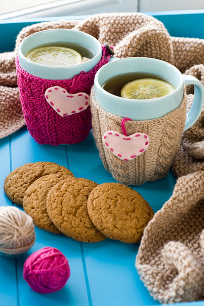 Two blue cup of tea in knitted sweater with hearts felt standing - Photo, Image