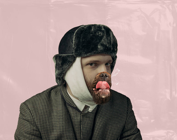 Oeuvre contemporaine Portrait d'homme barbu jouant le célèbre artiste Van Gogh avec des chiens bouche isolée sur fond rose. Concept d'art, comparaison des époques, mode. imitation, humour, publicité. Oreille bandée - Photo, image