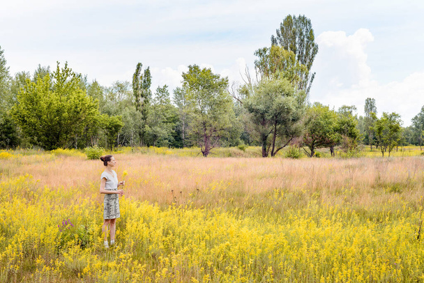 Woman Standing in a Field of Galium Verum - Foto, immagini