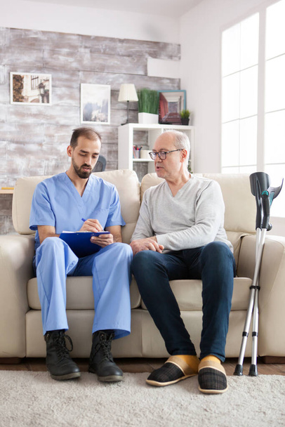 Old man in nursing home talking with male doctor - Photo, Image