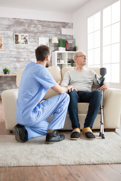 Joven médico en residencia de ancianos hablando con un anciano - Foto, Imagen