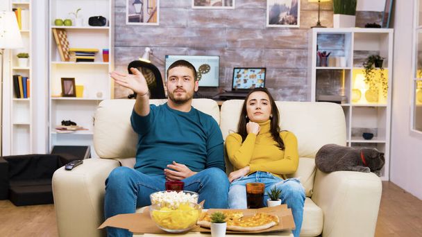 Homme barbu changer de chaînes de télévision avec des gestes de la main
 - Photo, image
