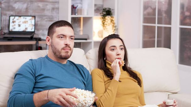 Couple sitting on couch eating fried chicken - Photo, Image