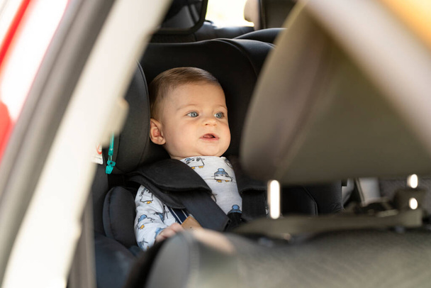 Ritratto di un bambino nel seggiolino auto che si guarda intorno - Foto, immagini