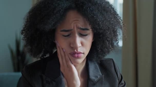 Jovem afro-americano encaracolado mulher de negócios toque bochecha sofrem de dor de dentes. Estudante doente sentir dor de dente dor dentária sangramento sensível gengivas cavidade oral cárie problema doença mal-estar doença - Filmagem, Vídeo