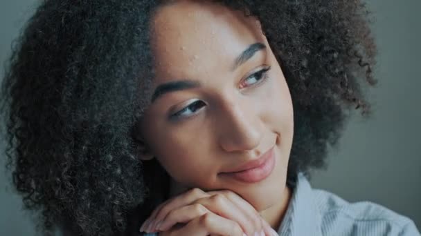 Close up head shot portrait dreamy beautiful african ethnic woman sitting at home dreaming about future remembering positive moments carefree young 20s face female student joyful single smiling lady - Footage, Video