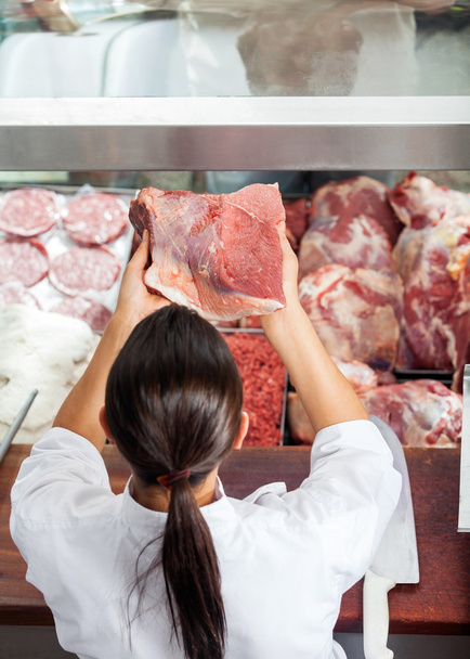 Female Butcher Holding Red Meat At Butchery - Foto, imagen