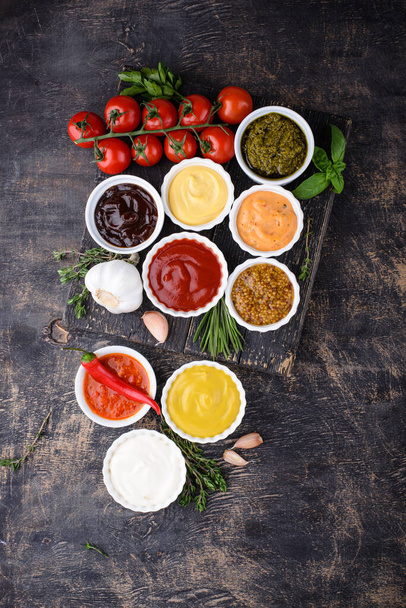 Set van verschillende sauzen. Ketchup, mosterd, mayonaise, pesto, marinara, adjika en kaasdip - Foto, afbeelding