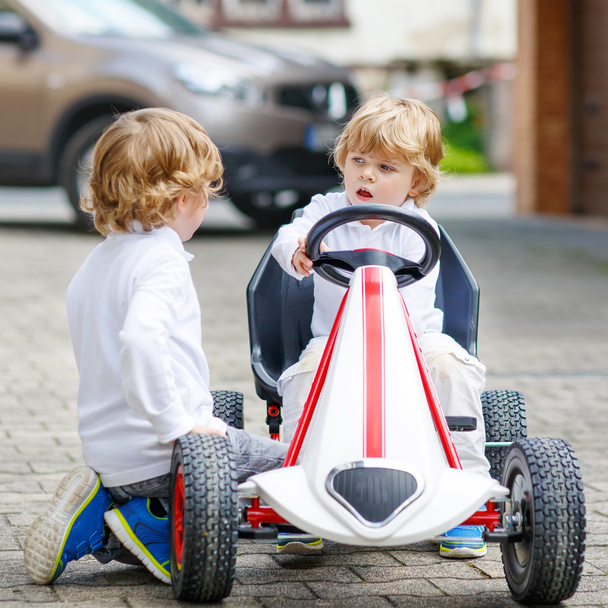 Two happy sibling boys playing with toy car - Foto, Bild